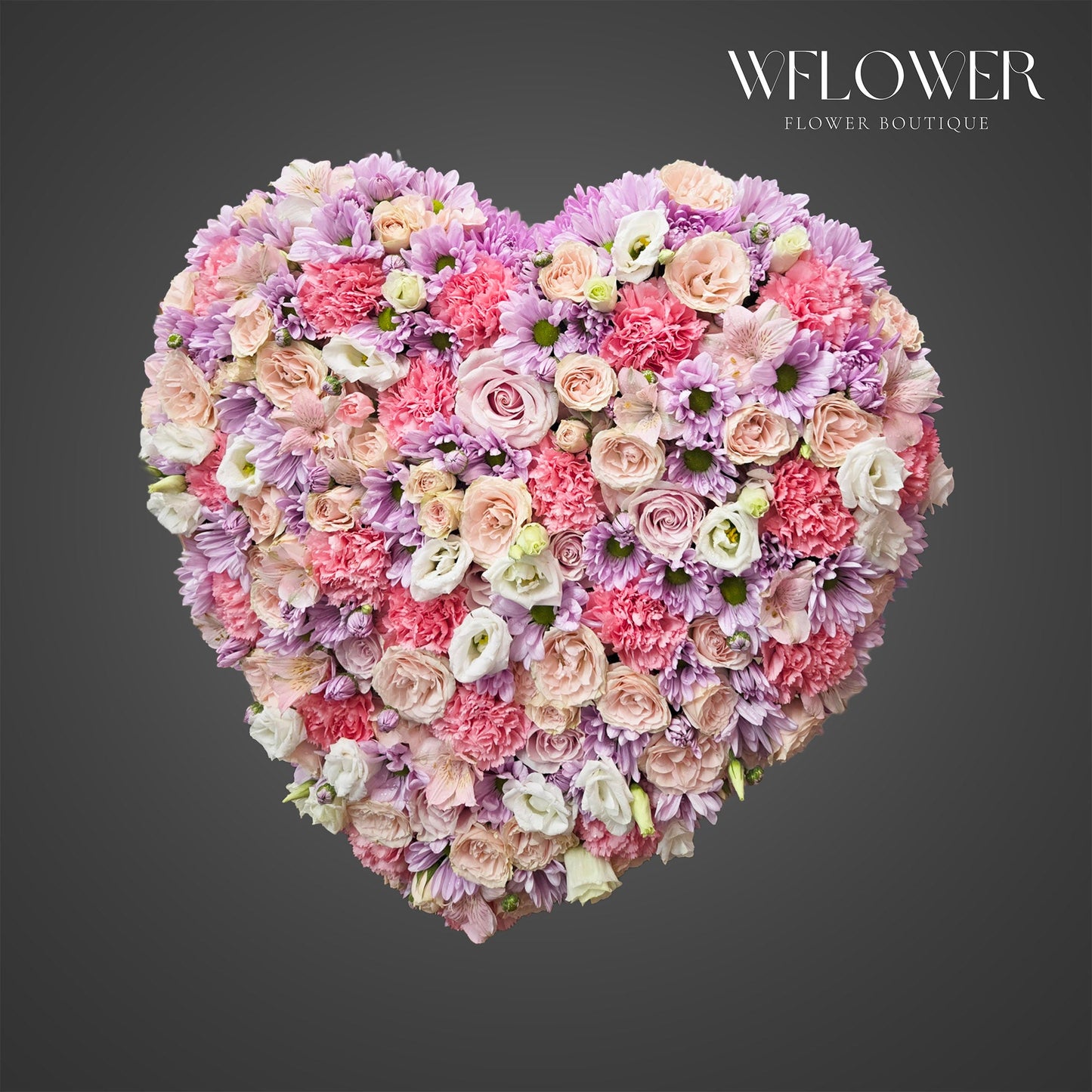 Heart shaped standing sympathy flower arrangement with pink, lavender, and white flowers by WFLOWER